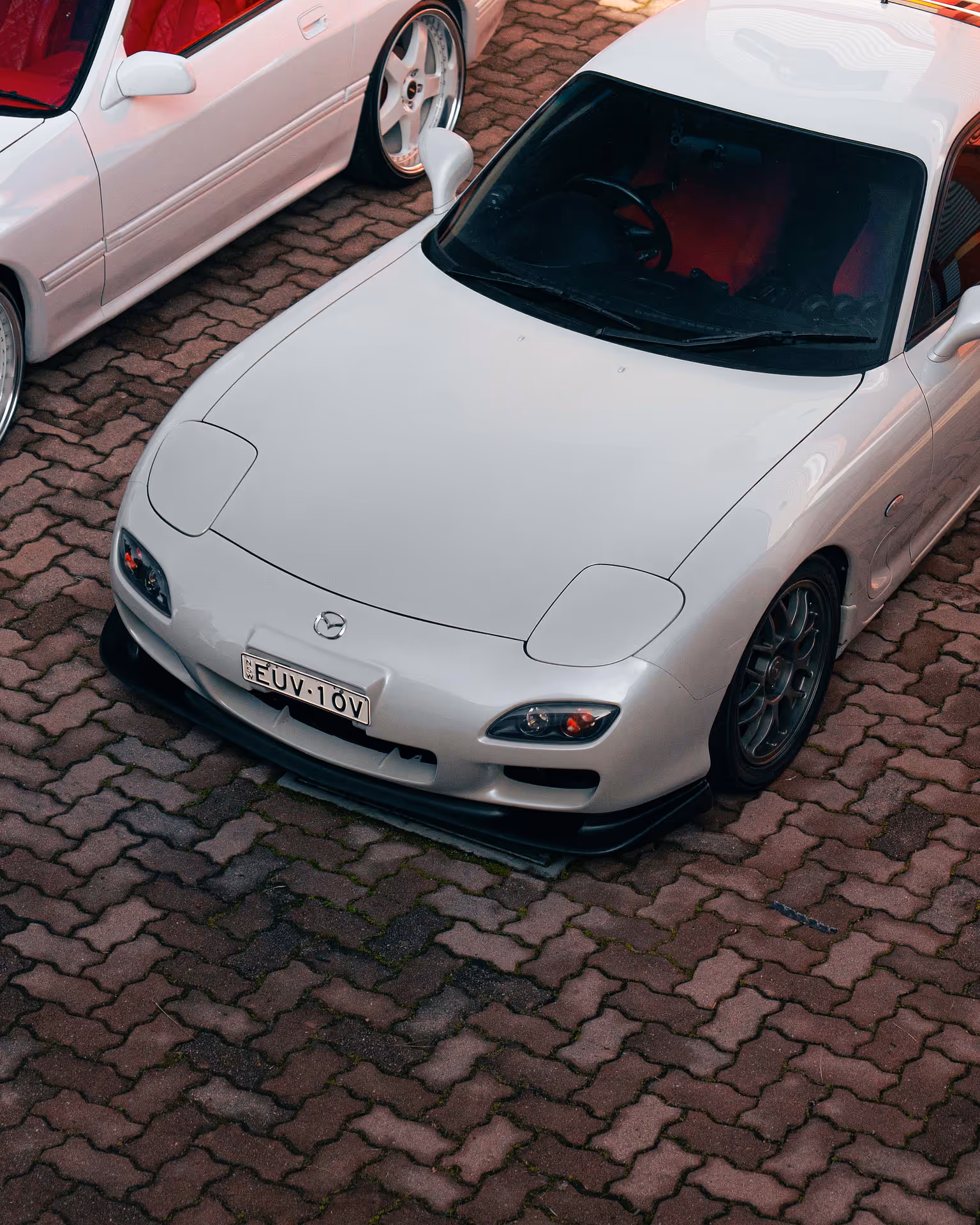 A white car, parked over bricks